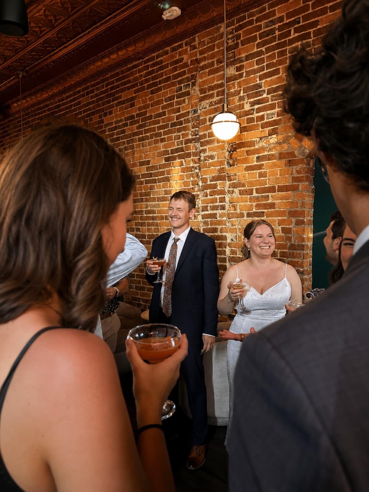 Private event at Dabney & Co. — guests with cocktails, exposed brick